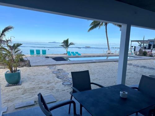 a view of a beach with tables and chairs at Pension Irivai, Appartement RAVA 1 chambre bord de mer in Uturoa