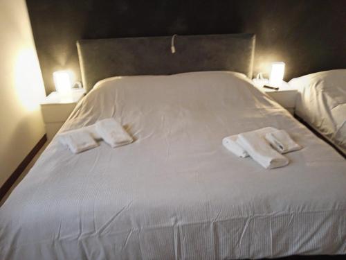 a white bed with two towels on top of it at Rifugio degli Dei in Monzuno