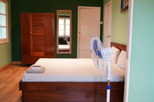 a bedroom with a bed with a fan on it at Residencial Avenida Geovanni in São Tomé