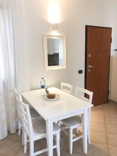 a white dining room table with white chairs and a mirror at Boavista Beach Apartment in Sal Rei