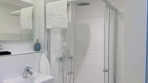 a white bathroom with a shower and a sink at Familienfreundlich - Eleganz im Hunsrück, nahe Mosel in Morbach