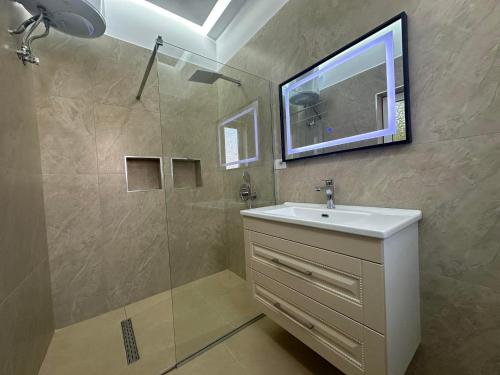 ein Bad mit einem Waschbecken und einer Dusche in der Unterkunft Algen Room's in Berat