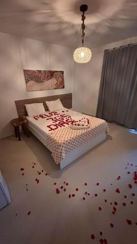 a bedroom with a bed with red petals on the floor at Pousada Águas de Tamandaré in Tamandaré