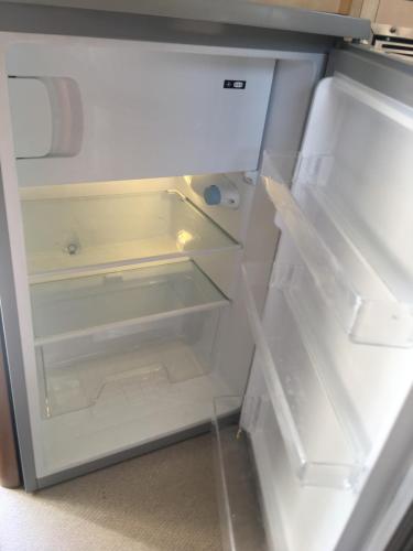 an empty refrigerator with its door open at Autocaravana Lisboa in Frielas