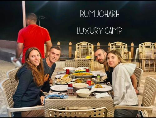 a group of people sitting at a table eating food at RUM JOHARH lUXURY CAMP in Wadi Rum