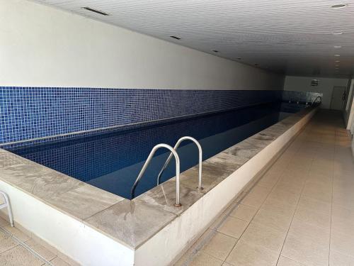 una piscina en un edificio con azulejos azules en Lindo ap garden Soul Paulista 102, en São Paulo