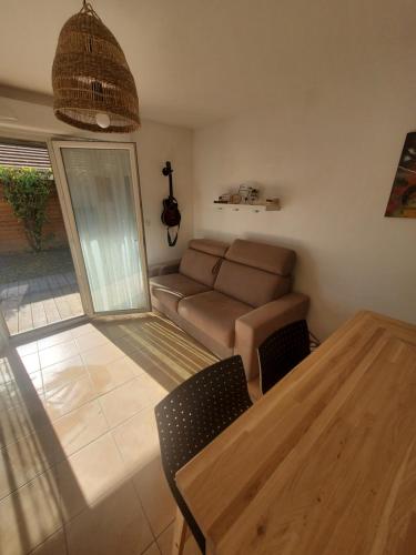 a living room with a couch and a table at A la ville, à la montagne in Marignier