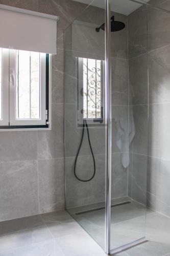 a shower with a glass door in a bathroom at Casa na Aldeia 1º Andar in Arcos de Valdevez
