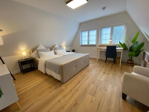 a large bedroom with a bed and a desk at Stadtoase: Exklusive Apartments für Ruhe und Entspannung in Bremen