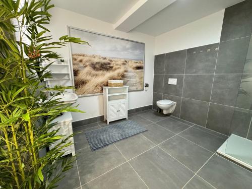 een badkamer met een toilet en een schilderij aan de muur bij Stadtoase: Exklusive Apartments für Ruhe und Entspannung in Bremen