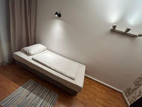 a small bed in a room with a wall at WestEnd#103 in Frankfurt