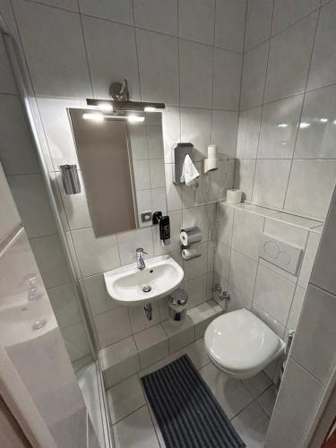 a white bathroom with a sink and a toilet at WestEnd#103 in Frankfurt