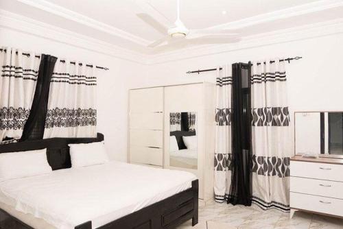 1 dormitorio con cama, tocador y espejo en Ej guest house en Banjul