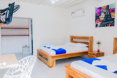 1 dormitorio con 2 camas y TV. en HOTEL PIEDRA VIVA, en Capurganá