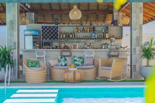 eine Bar mit Korbstühlen neben einem Pool in der Unterkunft HOTEL PIEDRA VIVA in Capurganá