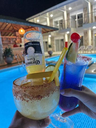 a person holding a drink in a bowl next to a pool at HOTEL PIEDRA VIVA in Capurganá