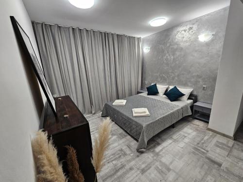 1 dormitorio con cama con almohadas azules y piano en 24 Shades of Grey, apartament central, ceai, cafea, filtru apa rece-fierbinte, pat 160 cm cu saltea memory foam, en Craiova