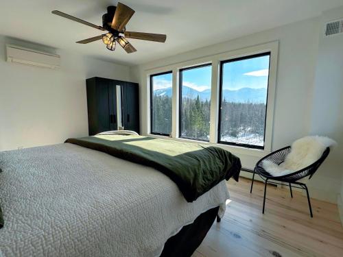 a bedroom with a bed and a fan and windows at 2M New rustic contemporary home with stunning views, great amenities and perfect private location. in Franconia