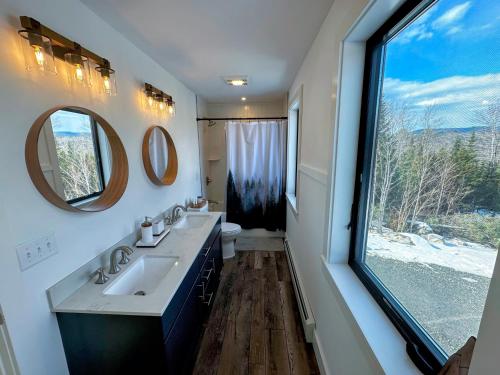 a bathroom with two sinks and a large window at 2M New rustic contemporary home with stunning views, great amenities and perfect private location. in Franconia
