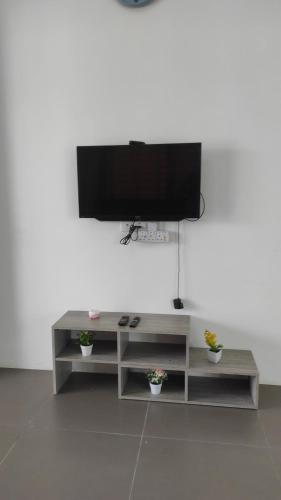 un centro de entretenimiento con TV de pantalla plana en la pared en Aaira Homestay d'Alor Setar, en Alor Setar