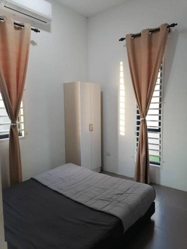 a bedroom with a bed and two windows at Aaira Homestay d'Alor Setar in Alor Setar