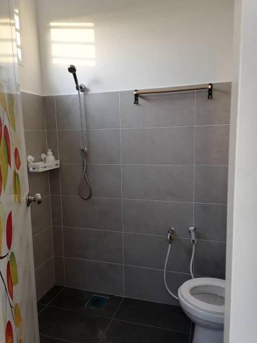 a bathroom with a shower and a toilet at Aaira Homestay d'Alor Setar in Alor Setar