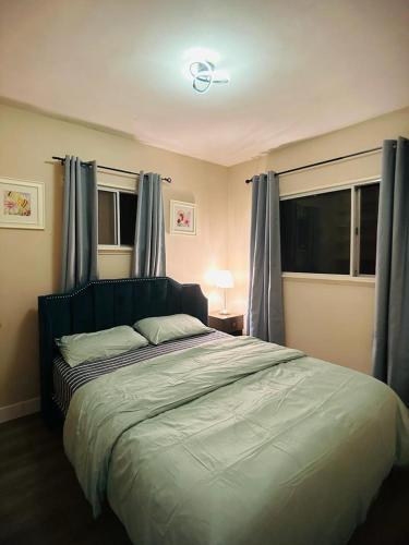 a bedroom with a large bed with blue curtains at 3 BHK House in Cultus Lake in Chilliwack