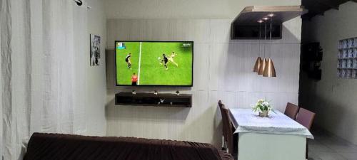 salon z telewizorem na ścianie w obiekcie Aconchego Lagoinha w mieście Florianópolis