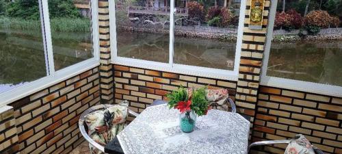 een tafel met een vaas met bloemen op een patio bij Aconchego Lagoinha in Florianópolis