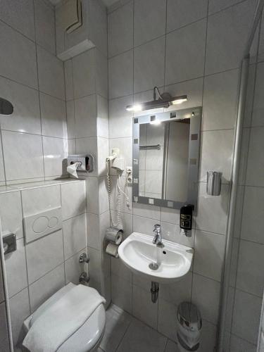 uma casa de banho com um lavatório, um WC e um espelho. em WestEnd#202 em Frankfurt am Main