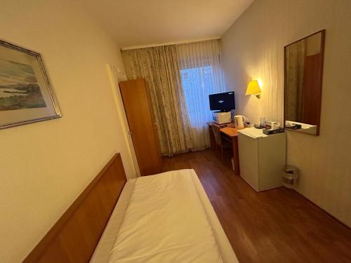 a hotel room with a bed and a desk with a computer at WestEnd#202 in Frankfurt