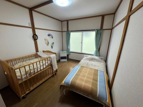 two twin beds in a room with a window at 名寄ベース in Nayoro