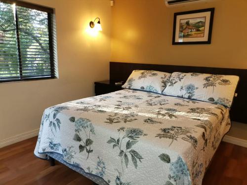a bedroom with a bed with a blue and white blanket at Airport Costa Rica B&B in Alajuela City