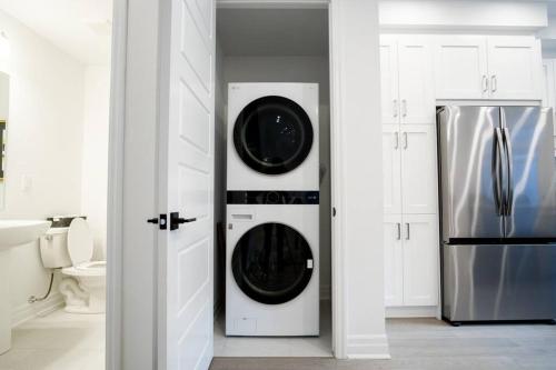 a kitchen with a washer and dryer next to a refrigerator at Modern 4-Bed Townhome with Cinema & Roof Terrace in Oakville