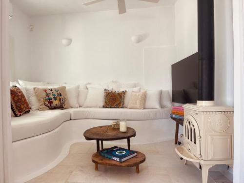 a white living room with a white couch and a table at ROMEO AND JULIO SUMMER HOUSE in Mýkonos City