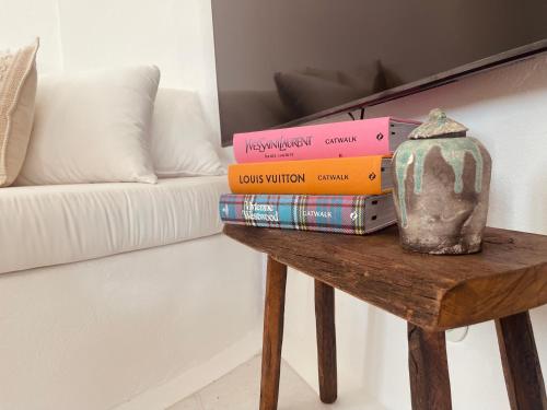 a pile of books on a table next to a couch at ROMEO AND JULIO SUMMER HOUSE in Mýkonos City