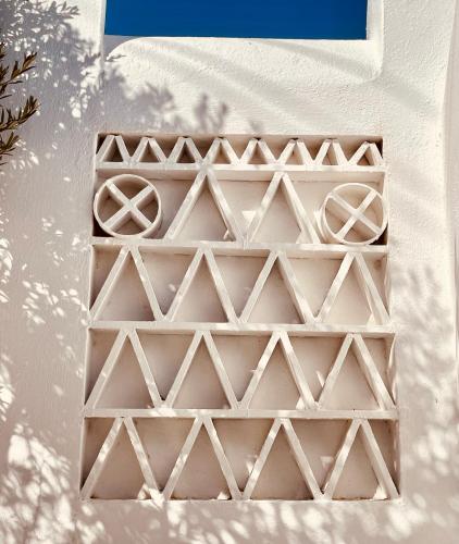 a white grate on the side of a white wall at ROMEO AND JULIO SUMMER HOUSE in Mýkonos City