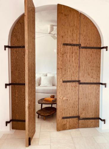 a room with a wooden partition with a bed and a table at ROMEO AND JULIO SUMMER HOUSE in Mýkonos City