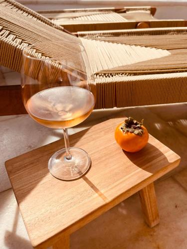 a glass of wine and a donut on a wooden table at ROMEO AND JULIO SUMMER HOUSE in Mýkonos City
