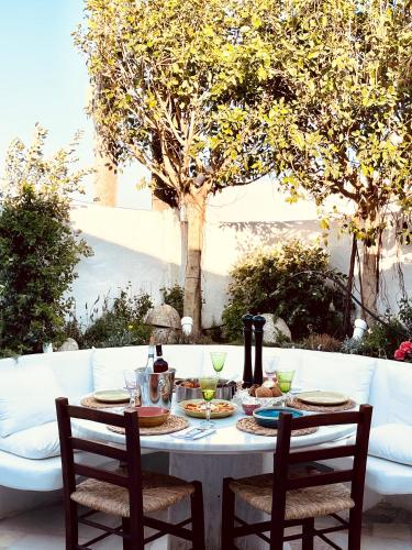a white table with two chairs and a table with food at ROMEO AND JULIO SUMMER HOUSE in Mýkonos City