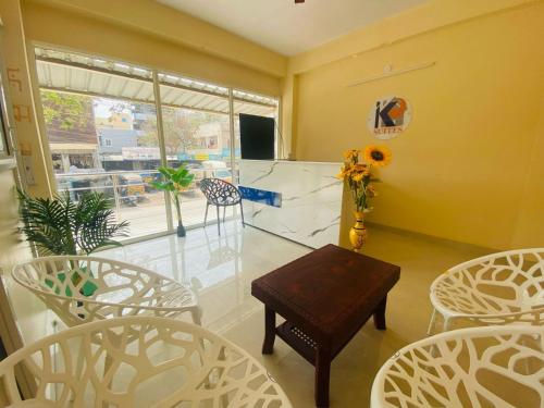 a room with chairs and a table and a window at Hotel KP Suites Airport in Shamshabad