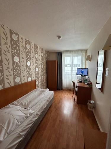 a bedroom with a bed and a desk with a television at WestEnd#204 in Frankfurt