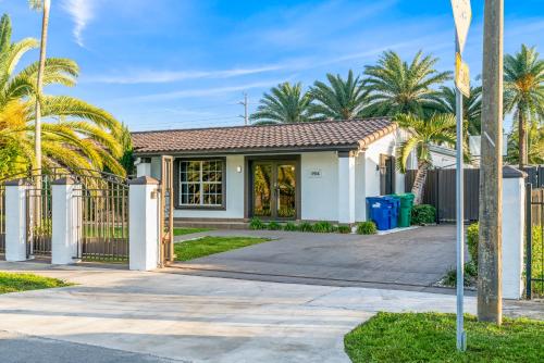 a house with a gate and palm trees at Oasis with Pool Spa Games 5BR L21 in Miami Gardens