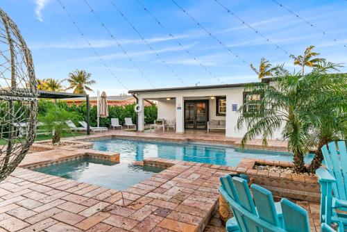 a swimming pool with blue chairs and a house at Oasis with Pool Spa Games 5BR L21 in Miami Gardens