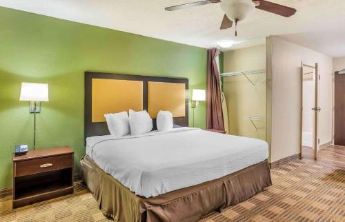 - une chambre avec un grand lit et un mur vert dans l'établissement Extended Stay America Select Suites - Philadelphia - Malvern - Great Valley, à Malvern