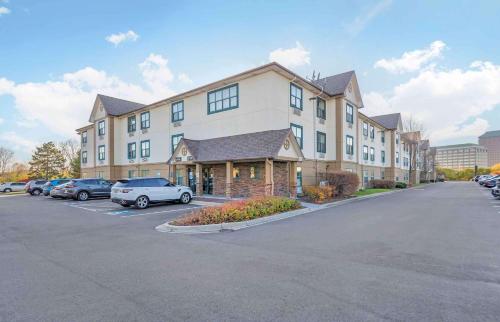 a large building with cars parked in a parking lot at Extended Stay America Select Suites - Chicago - Downers Grove in Downers Grove
