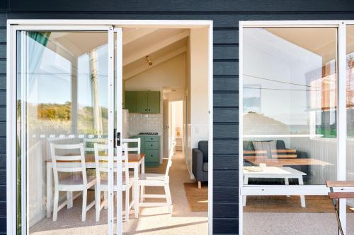 a kitchen and dining room with sliding glass doors at Surf Beach Narooma Holiday Park in Narooma