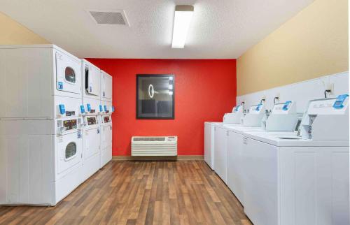 a laundry room with white washing machines and red walls at Extended Stay America Suites - Minneapolis - Airport - Eagan - South in Eagan