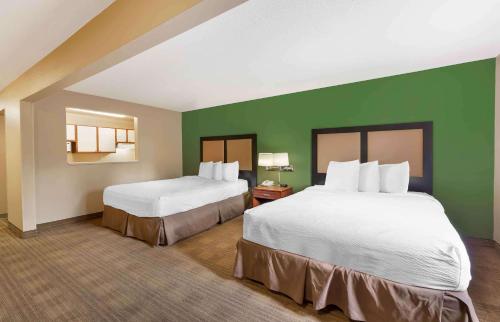two beds in a hotel room with green walls at Extended Stay America Suites - Chicago - Lombard - Yorktown Center in Lombard