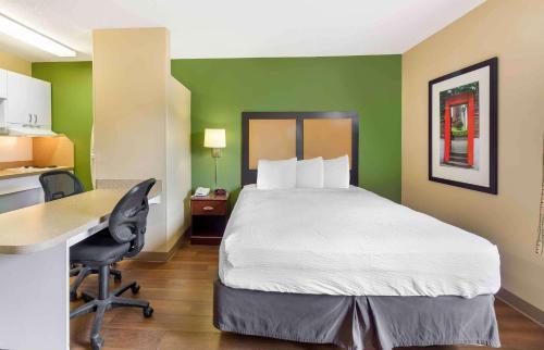 a hotel room with a bed and a desk and a computer at Extended Stay America Suites - Memphis - Germantown West in Memphis